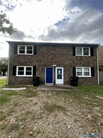 a view of a brick house next to a yard
