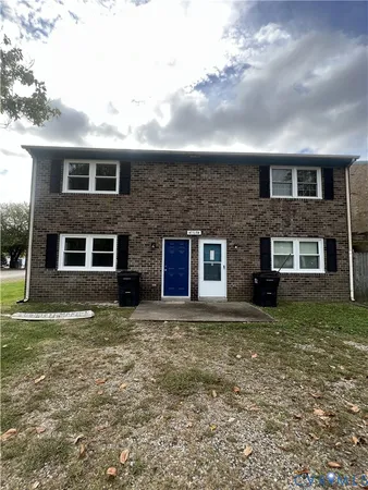 a view of a brick house next to a yard