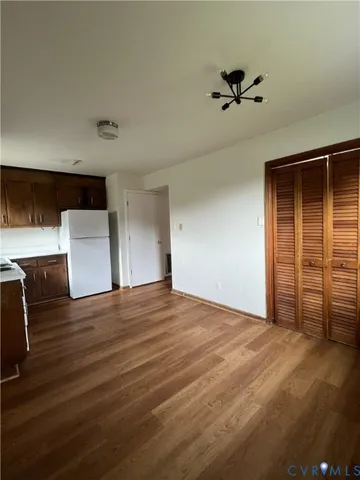 an empty room with wooden floor and cabinet