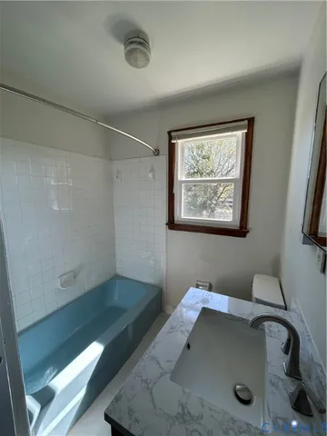 a bathroom with a tub and a window