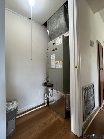 a view of hallway with wooden floor and cabinet
