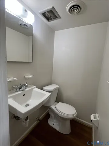a bathroom with a toilet a sink and mirror