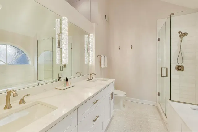 a bathroom with a shower sink vanity mirror and toilet