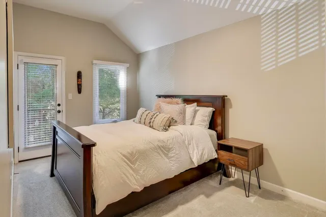 a bedroom with a bed and a lamp next to a window