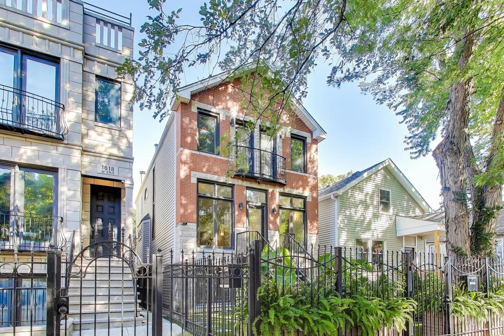 1614 West Erie Street Chicago, IL 60622 - Photo 3 of 50 a view of a brick house with large windows and a tree