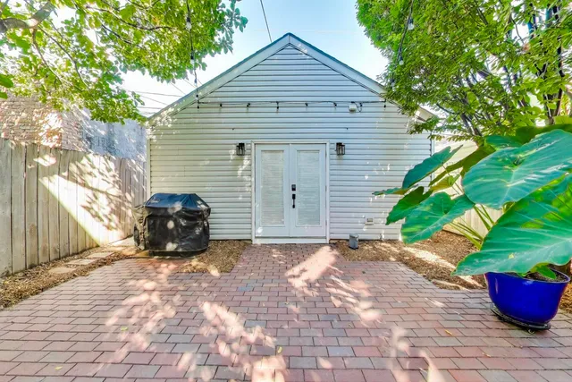 a view of a house with a small yard and a large tree