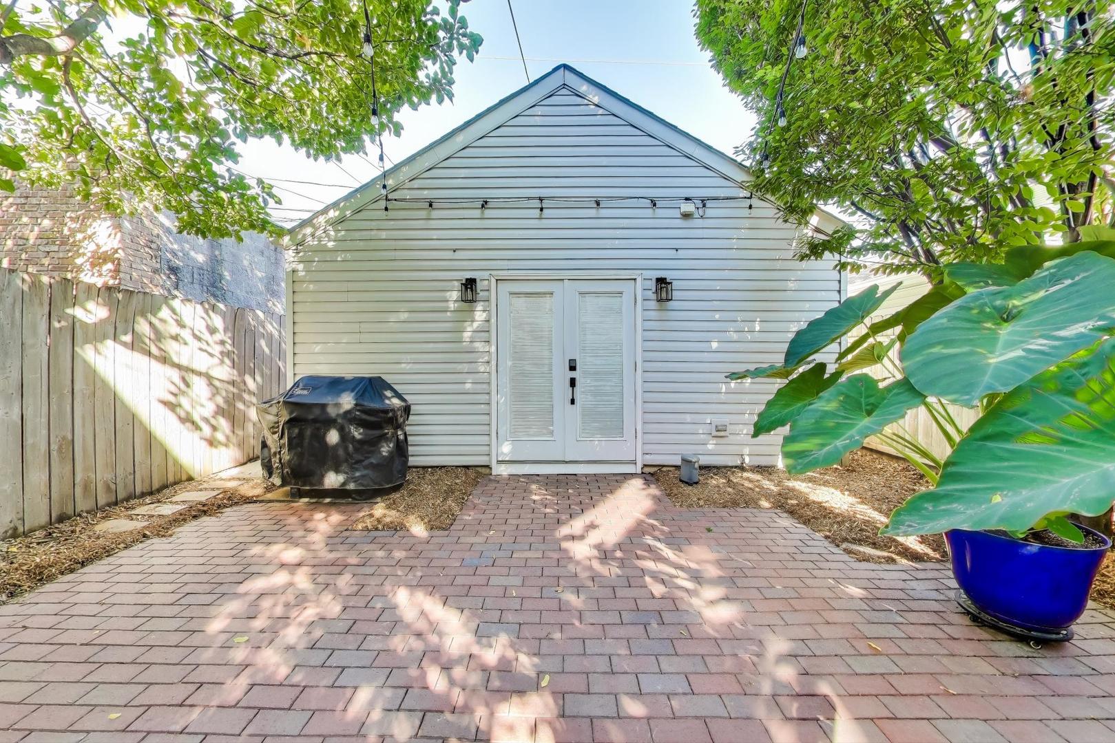 1614 West Erie Street Chicago, IL 60622 - Photo 41 of 50 a view of a house with a small yard and a large tree