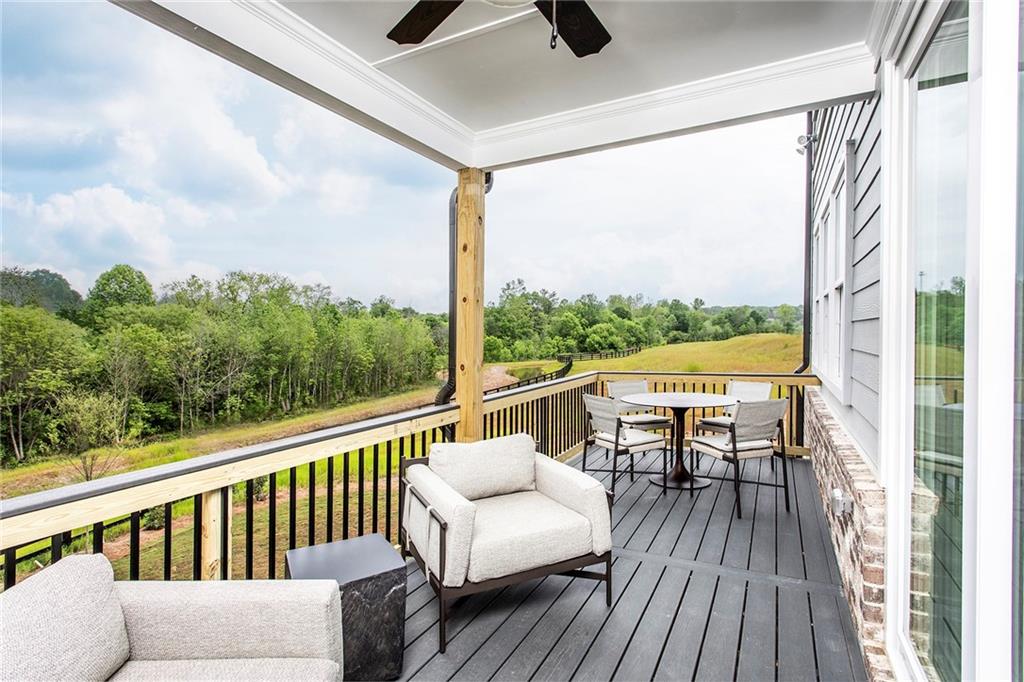 4765 Montane Street Cumming, GA 30028 - Photo 16 of 50 a balcony with wooden floor and outdoor seating