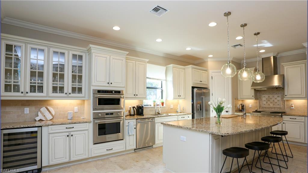 a kitchen with stainless steel appliances kitchen island granite countertop a stove and cabinets