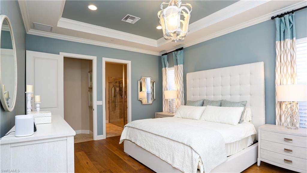10155 Coconut Road Estero, FL 34135 - Photo 12 of 34 a bedroom with a large bed and a chandelier