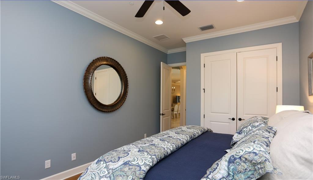 10155 Coconut Road Estero, FL 34135 - Photo 18 of 34 a bedroom with a bed and a chandelier