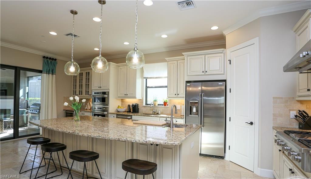 10155 Coconut Road Estero, FL 34135 - Photo 2 of 34 a kitchen with stainless steel appliances granite countertop a sink refrigerator and cabinets
