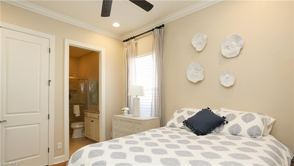 10155 Coconut Road Estero, FL 34135 - Photo 23 of 34 a large bed in a bedroom next to a window and a bathroom