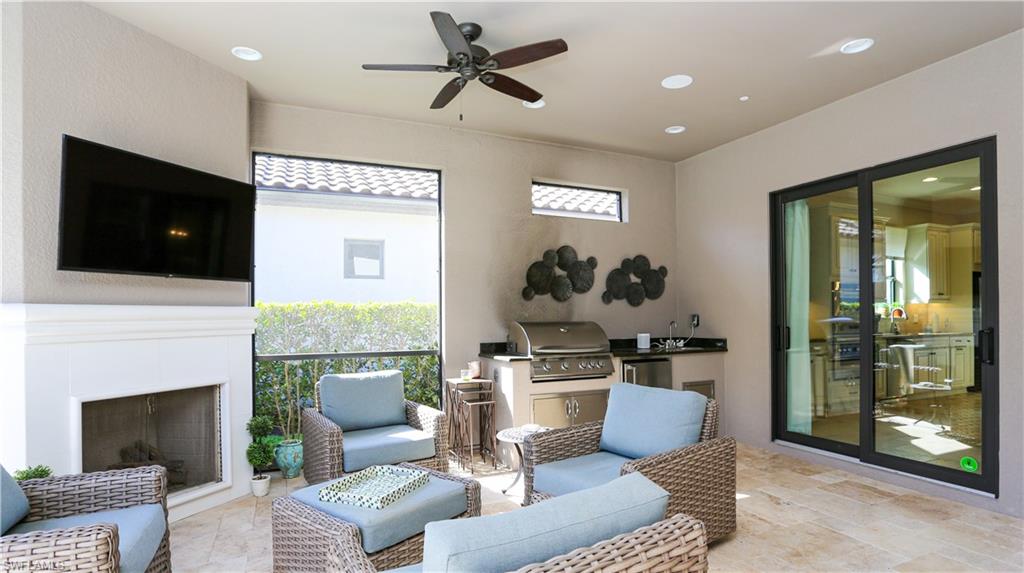 10155 Coconut Road Estero, FL 34135 - Photo 29 of 34 a living room with furniture a fireplace and a flat screen tv