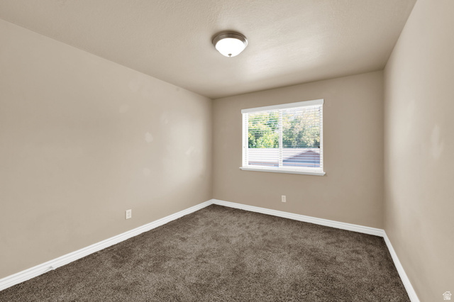 909 South Main Street, Unit G Layton, UT 84041 - Photo 18 of 25 Carpeted room featuring a single window with blinds, a ceiling-mounted light fixture, and neutral-toned walls