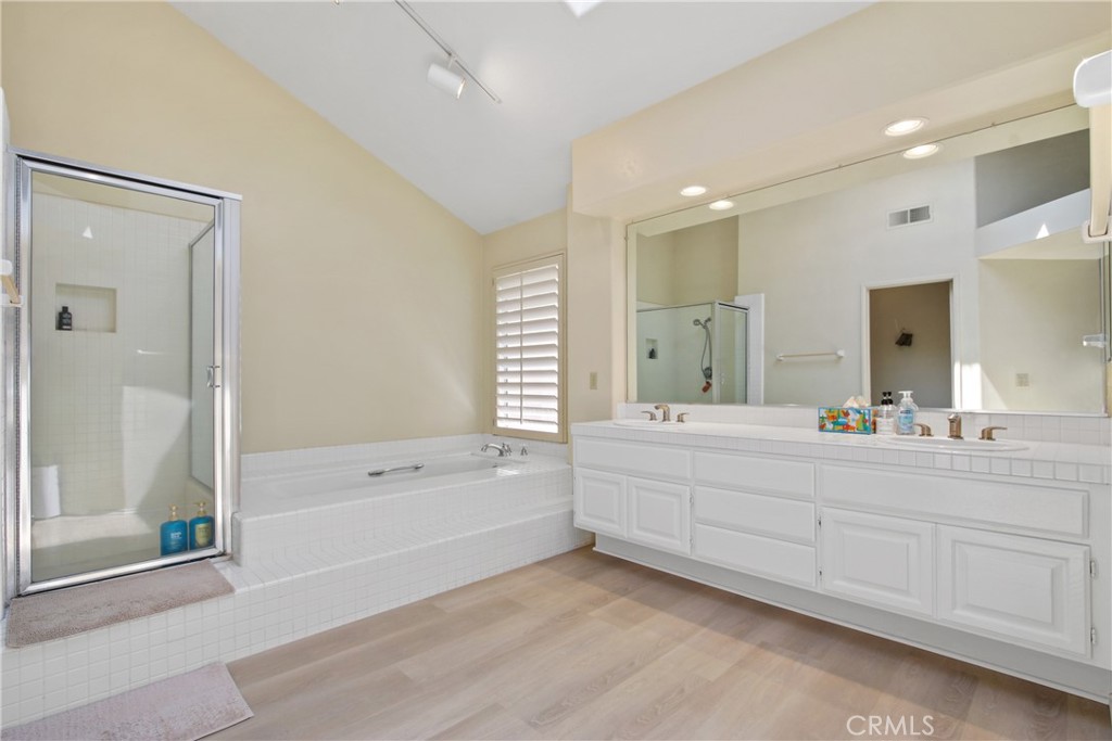 9221 Belcaro Drive Huntington Beach, CA 92646 - Photo 16 of 22 a bathroom with a tub sink shower and mirror