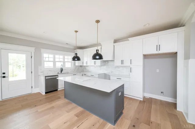 a large white kitchen with a sink and window