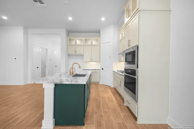 a kitchen with stainless steel appliances granite countertop a refrigerator a sink dishwasher and a stove with wooden floor