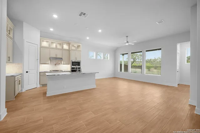 a large kitchen with stainless steel appliances granite countertop a large counter top and a wooden floors