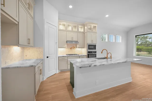 a kitchen with stainless steel appliances granite countertop a sink stove and cabinets