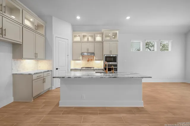 a large kitchen with kitchen island a large counter top and a sink