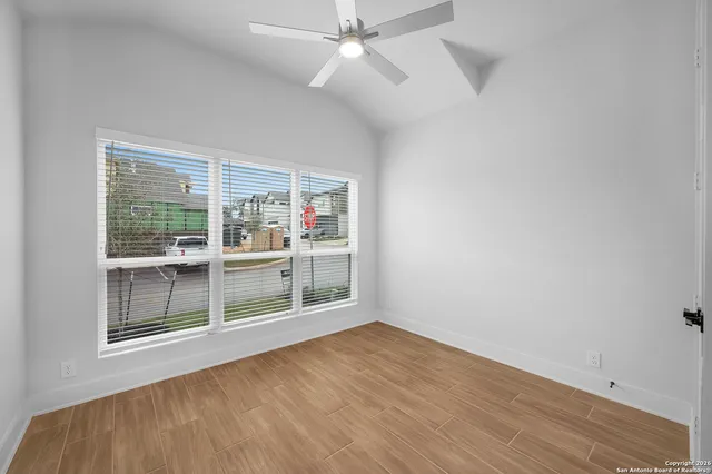 an empty room with wooden floor and windows