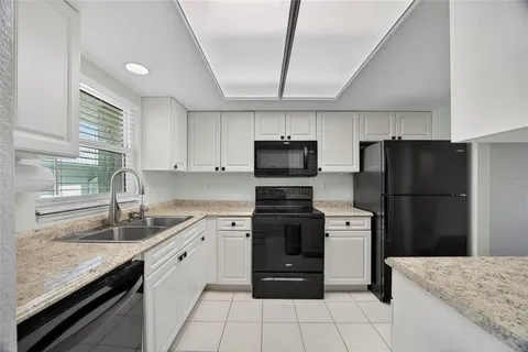 a kitchen with stainless steel appliances granite countertop a refrigerator sink and stove
