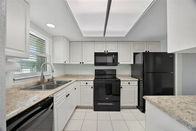 a kitchen with stainless steel appliances granite countertop a refrigerator sink and stove