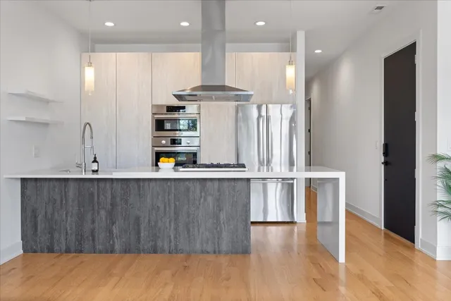 a view of kitchen with stainless steel appliances cabinets and wooden floor
