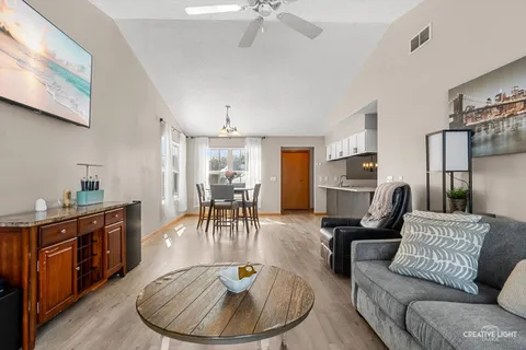 a living room with furniture a dining table and a chandelier