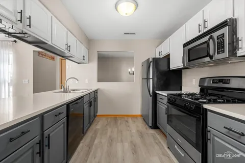 a kitchen with stainless steel appliances a stove microwave and sink