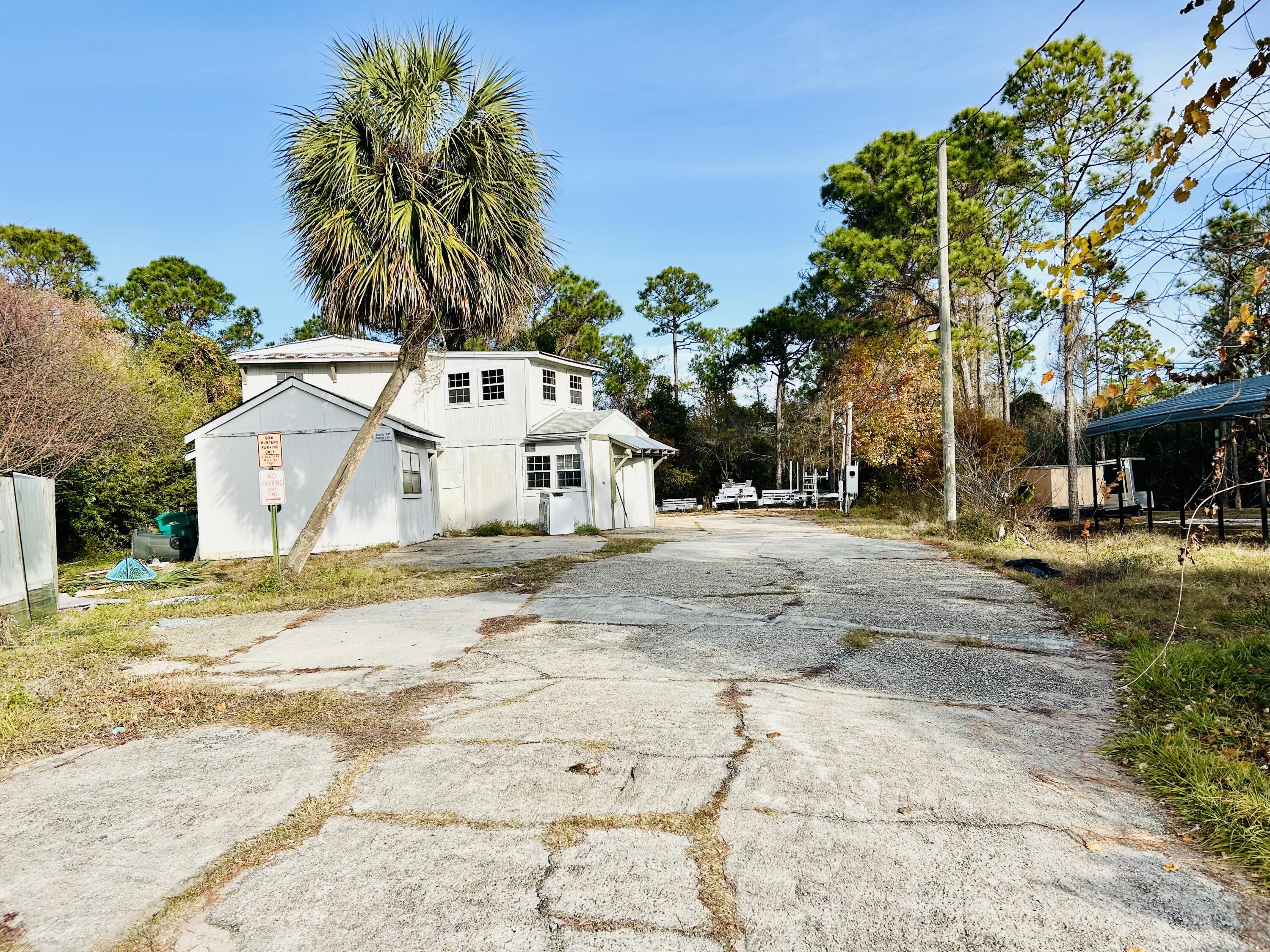 139 North Holiday Road Miramar Beach, FL 32550 - Photo 2 of 5 a view of a white house with a yard and palm trees