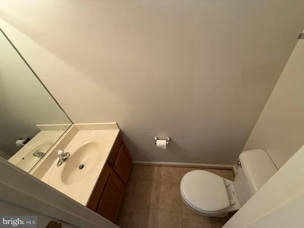 a bathroom with a toilet mirror and vanity