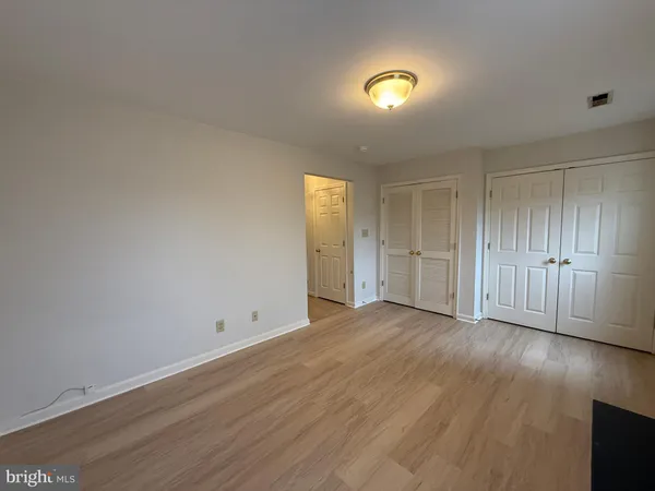 a view of empty room with wooden floor and window