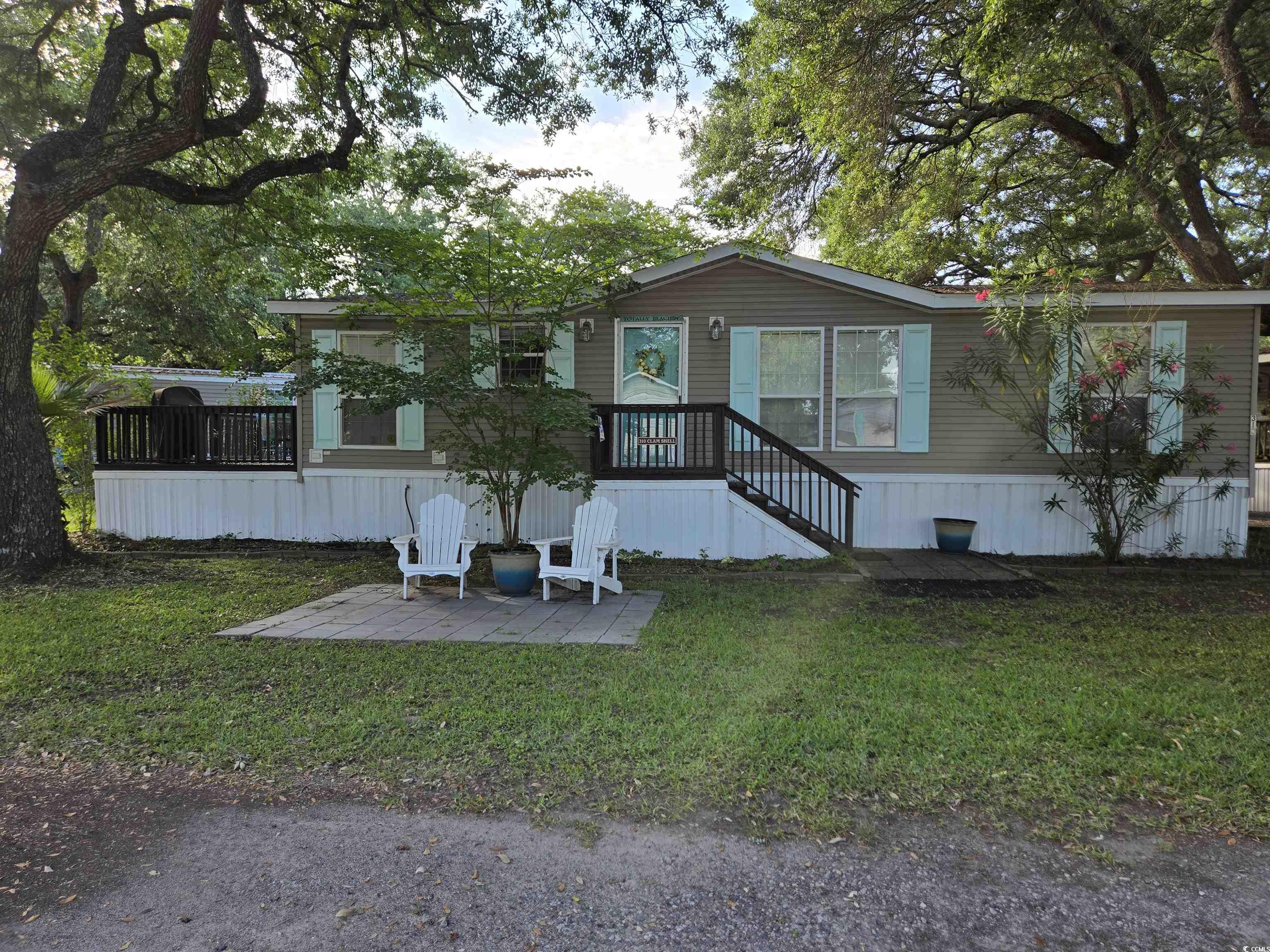Manufactured / mobile home featuring a front lawn and a patio