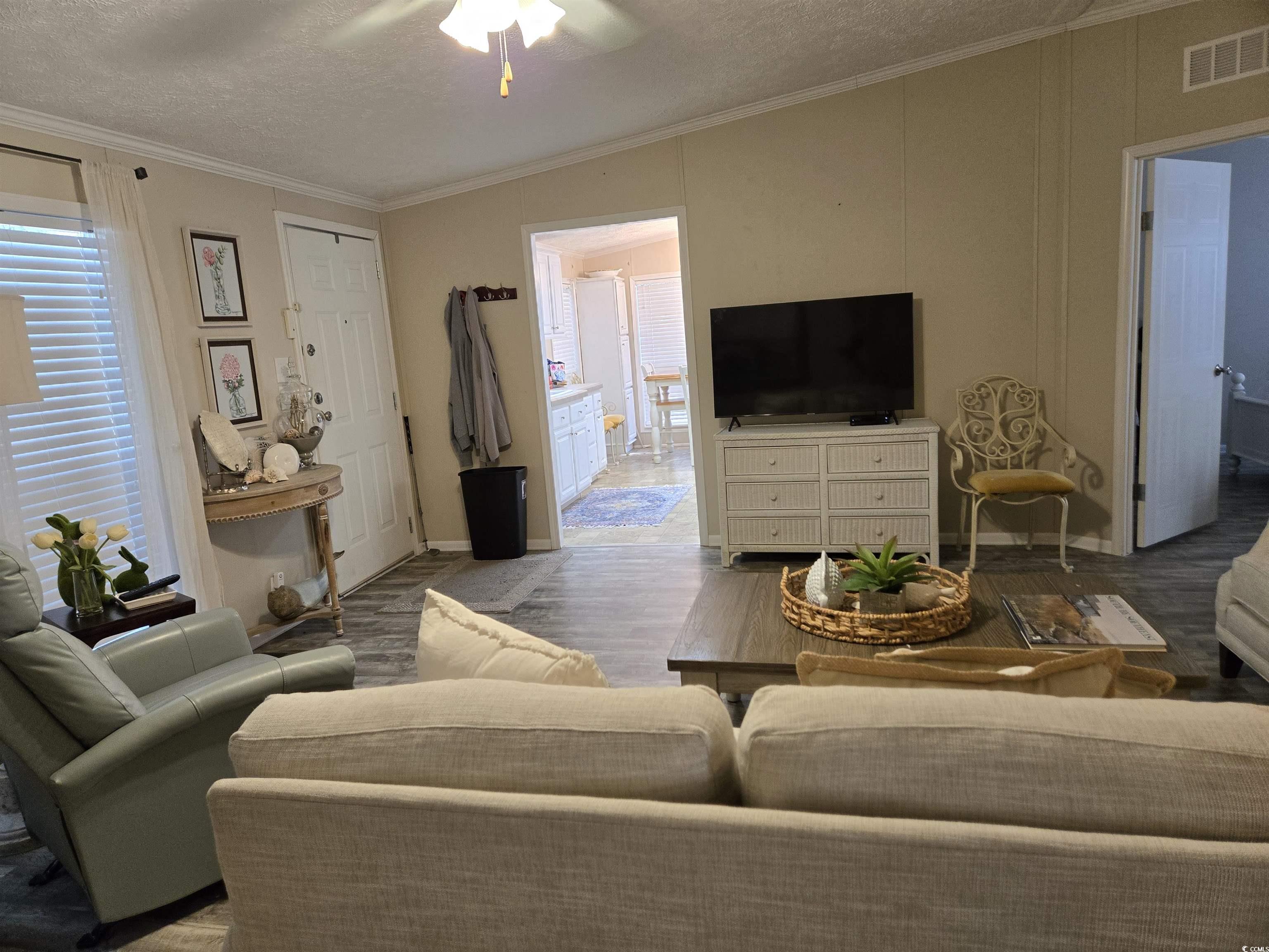 310 Clam Shell Circle Murrells Inlet, SC 29576 - Photo 12 of 32 Living area featuring wood finished floors, a textured ceiling, a ceiling fan, crown molding, and baseboards