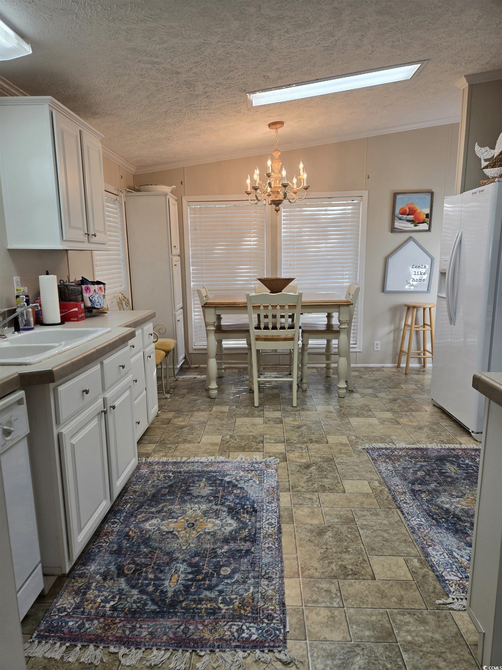 310 Clam Shell Circle Murrells Inlet, SC 29576 - Photo 13 of 32 Kitchen with white appliances, a sink, white cabinets, a chandelier, and ornamental molding