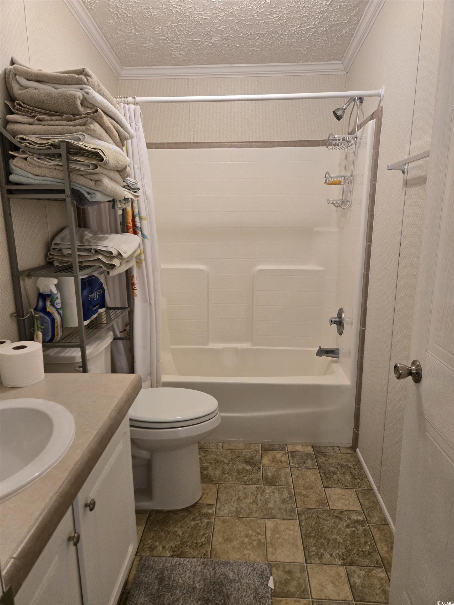 310 Clam Shell Circle Murrells Inlet, SC 29576 - Photo 21 of 32 Bathroom with shower / tub combo with curtain, ornamental molding, vanity, stone finish flooring, and a textured ceiling