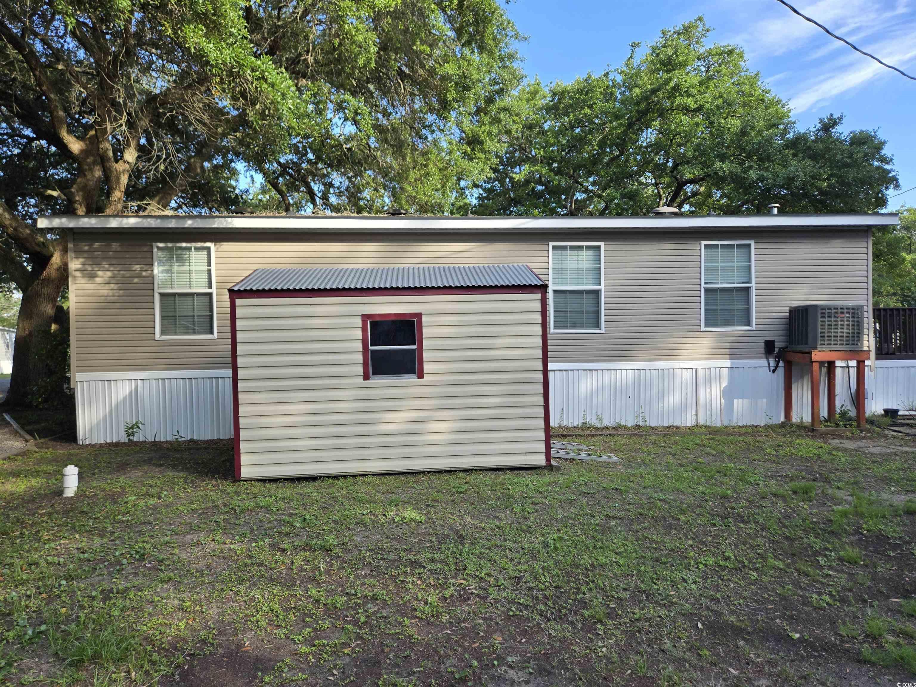 310 Clam Shell Circle Murrells Inlet, SC 29576 - Photo 9 of 32 View of home's exterior featuring an outdoor structure, a yard, and cooling unit