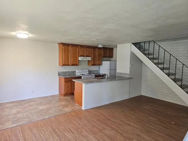 a kitchen with granite countertop a stove and a wooden floors