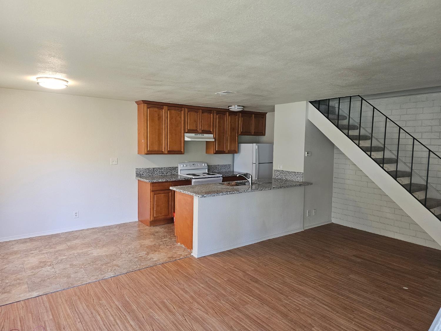 5830 Walerga Road, Unit 2 Sacramento, CA 95842 - Photo 2 of 8 a kitchen with granite countertop a stove and a wooden floors