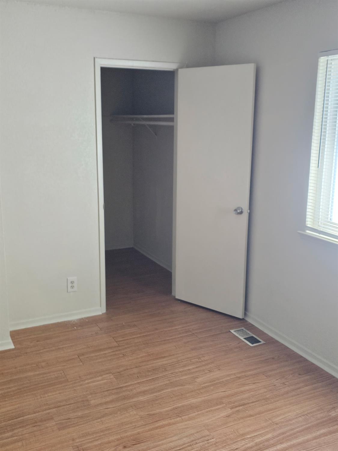 5830 Walerga Road, Unit 2 Sacramento, CA 95842 - Photo 8 of 8 an empty room with wooden floor and windows