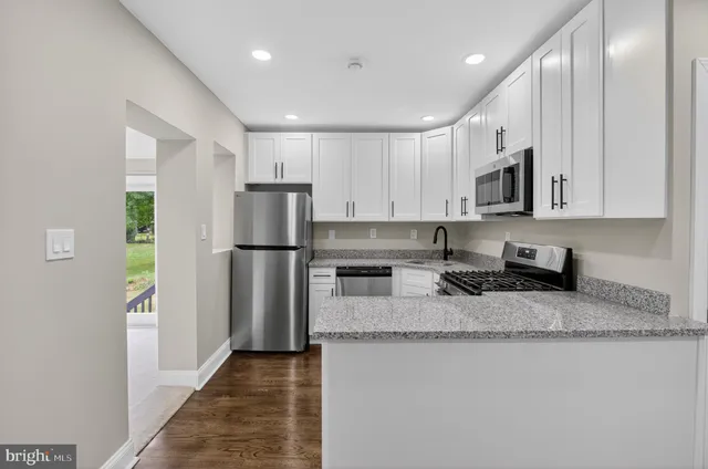 a kitchen with stainless steel appliances granite countertop a refrigerator a stove a sink and a granite counter tops