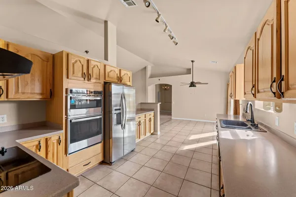 a kitchen with stainless steel appliances granite countertop a refrigerator and a stove top oven
