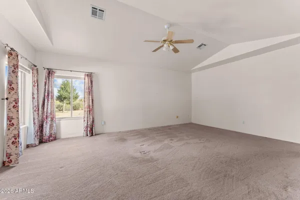 an empty room with windows and fan