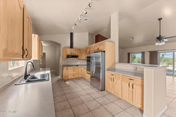 a kitchen with stainless steel appliances granite countertop a sink and a refrigerator