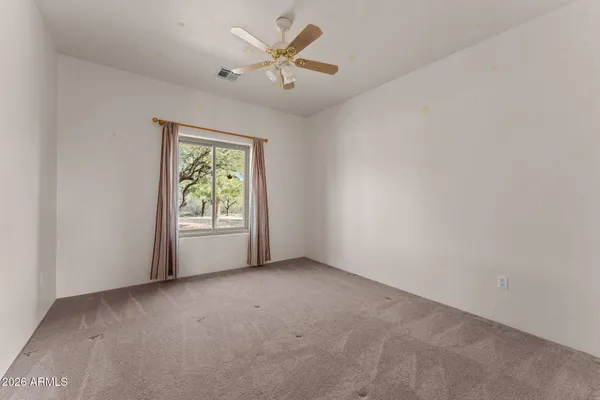 an empty room with windows and fan