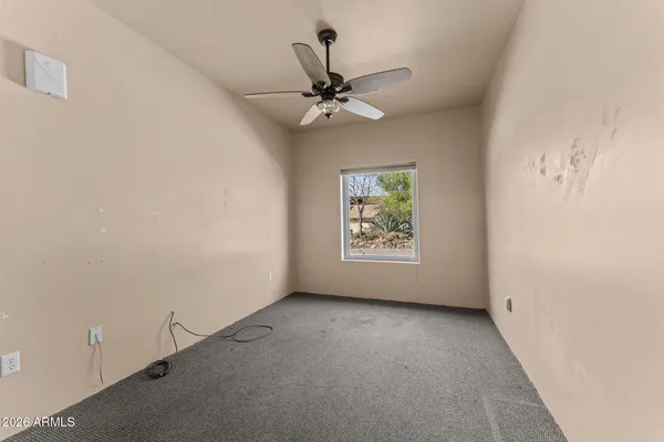 an empty room with windows and fan