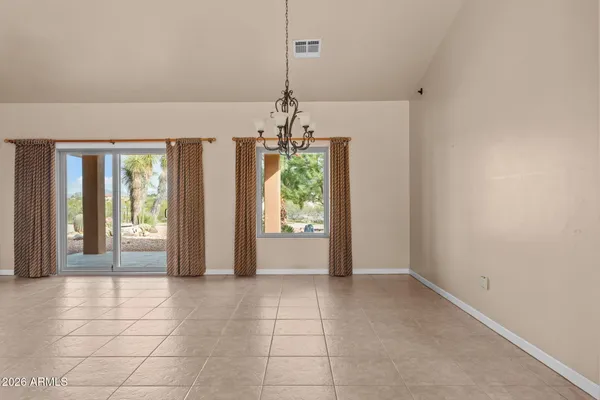 a view of a hallway with windows and chandelier