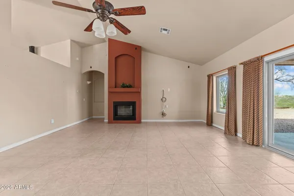 a view of empty room with fireplace and fan